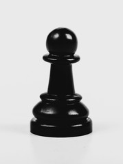 Single shiny black chess pawn isolated, matte, low contrast. One lonely chess piece on grey...