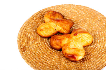 Two simple fresh homemade sweet buns isolated on white, dessert, closeup. Pair of bread rolls on an organic natural brown mug pad. Baking healthy tasty food at home, tea snack concept food photography
