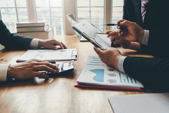 Group of business people meeting together to assess business profits.