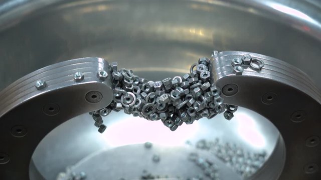 Closeup 4k video of two powerful magnets and many metal screw bolts stacked to them.