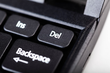 Little delete del laptop key macro, extreme closeup selective focus. Small laptop notebook key up close. Deleting important files data abstract concept, nobody