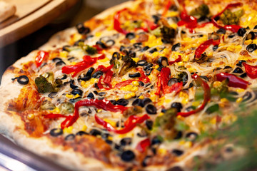 Traditional Italian pizza on thick crust background texture, shallow depth of field, top view surface texture closeup, macro. Freshly baked pizza straight from the oven, food photography