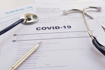 COVID-19 Health insurance concept. Stethoscope and pen on health insurance form