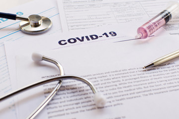 COVID-19 Health insurance concept. Syringe, pen and Stethoscope with copy space on application form...