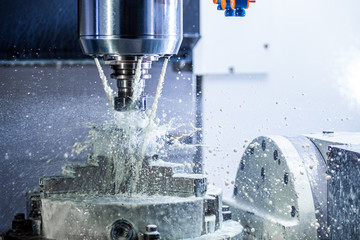 a process of industrial wet milling in 5-axis cnc machine with coolant flow under pressure and...