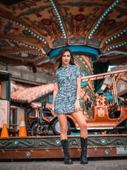 Fototapeta na wymiar Street style, young long-haired brunette in a carousel with short skirt