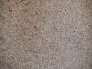 Brown gray grunge background. The texture of the old fiberboard. The texture of the old rough surface of the fiberboard. Old weathered fiberboard background for your design.