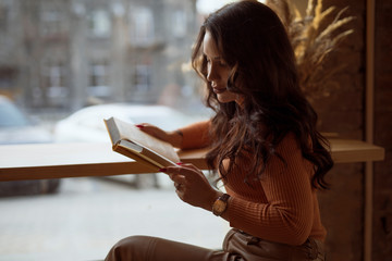 Young woman reading book in cafe