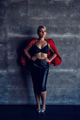 Fototapeta premium girl in a skirt and underwear posing against a dark wall