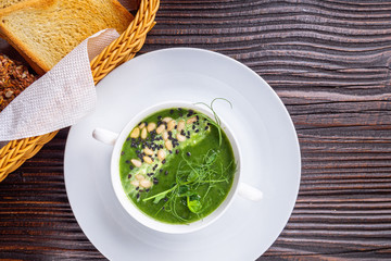 broccoli spinach cream soup on rustic wooden background