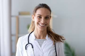 Head shot portrait smiling mixed race female doctor in uniform