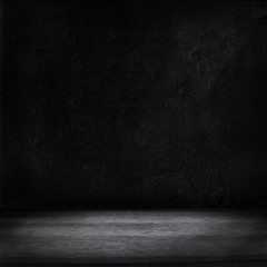 Wood table and black concrete wall background.