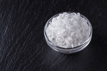 coarse sea salt on a dark stone background