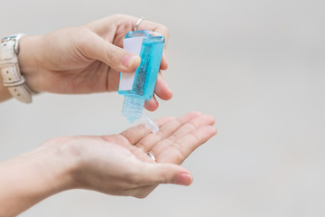 Woman hands using wash hand sanitizer gel dispenser, against Novel coronavirus or Corona Virus Disease (Covid-19) at public train station. Antiseptic, Hygiene and Healthcare concept