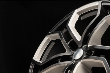 aluminum alloy wheel. Premium cast, the design of the spokes and the wheel rim, a white and black elements on dark background close-up