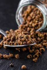 Sichuan pepper on a dark stone background