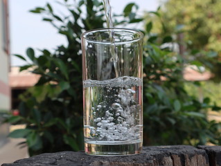 Filling water in glass with bubbles in summer.