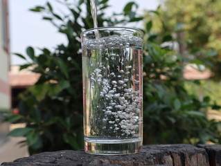 Filling water in glass with bubbles in summer.