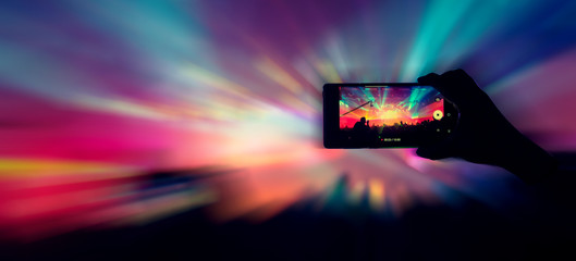 social media concept crowd people hand hold smartphone capture exitied moment in colorful lighting concert event with abstract blur bokeh background