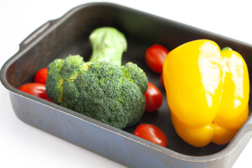 Broccoli, yellow bell pepper and red cherry tomatoes in a baking dish