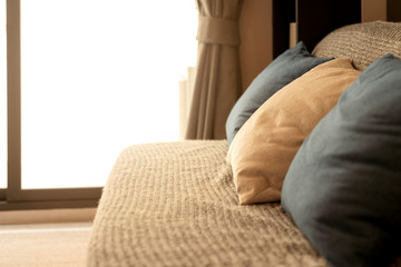 soft cozy beige color pillows on modern sofa with wallpaper wall cover background home design concept