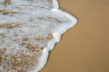 Soft wave of blue ocean on sandy beach. background. selective focus. beach and tropical sea white foam on beach. soft focus on bottom of picture.