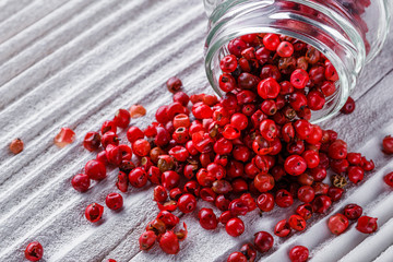 pink peppercorns on white wooden rustic background