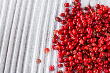 pink peppercorns on white wooden rustic background