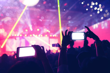 Fototapeta na wymiar social media concept crowd people hand hold smartphone capture exitied moment in colorful lighting concert event with abstract blur bokeh background