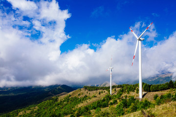 Fototapeta na wymiar Aerial view of wind turbine farm. Wind power plants in green summer landscape with clouds.
