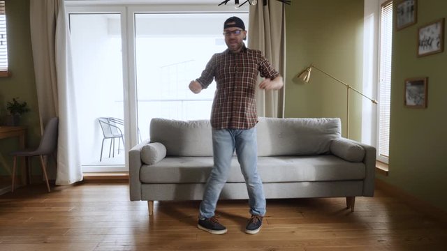 Happy Young Man Dancing at Home Living Room, Fun Celebrating Funny Viral Dance Freedom Weekend. Guy Enjoying Dance, Having Fun Party. Joyful Man Dancing Cheerful In Living Room. Slow Motion.