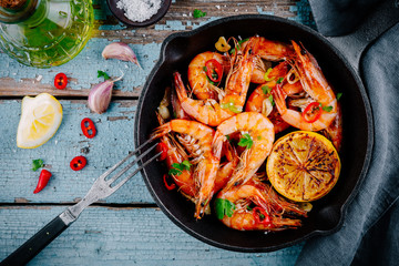 Roasted Prawns Shrimps in frying pan with lemon and chili pepper