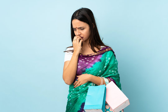 Young Indian Woman With Shopping Bags Having Doubts