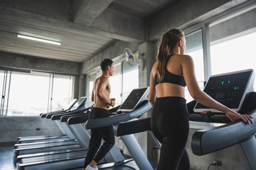 Fototapeta na wymiar Man and woman Exercising by running on the treadmill To maintain good health always