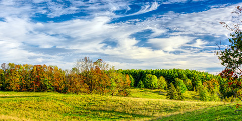 Panoramic high dynamic range image of autumn pasture and forested hills under a blue sky, Wingham, Huron County, southwestern Ontario, Canada