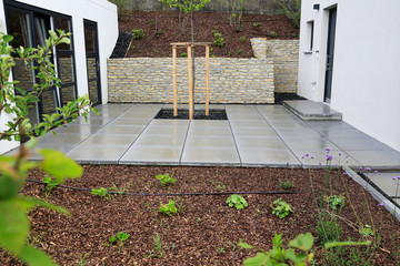 Moderner Gartenbau und Terrassengestaltung eines Neubaus an einem Hanggrundstück im Materialmix:...