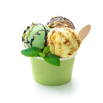 Various colorful ice cream balls with sauce and mint leaf in ice cup