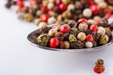 mix of peppercorns on white acrylic background