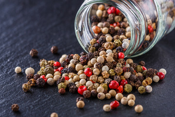 mix of peppercorns on a dark stone background