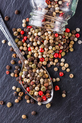 mix of peppercorns on a dark stone background