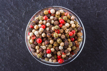 mix of peppercorns on a dark stone background