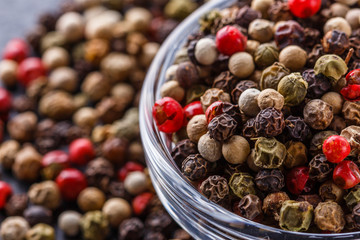 mix of peppercorns on a dark stone background