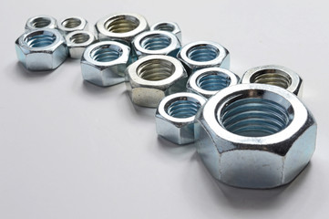 New chrome screw-nut of different sizes on a white background. Concept.