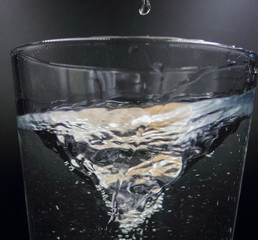 swirling spinning water in a glass with bubbles isolated on a black background
