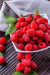 juicy fresh natural raspberries on a dark wooden rustic background
