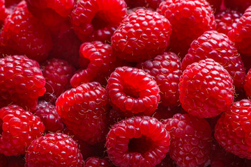 Juicy fresh natural raspberries on white acrylic background