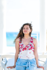 Seaside white pavilion by gulf of mexico ocean with water and happy young woman girl in Florida architecture view during sunny day steps to beach