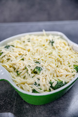 Fresh yummy food - broccoli with cheese on top of it in baking dish.