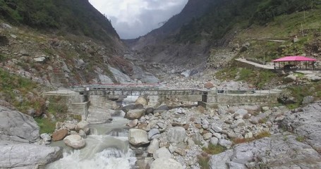 Beautiful backward aerial sweep above hills & Holy Indian river Ganges in upper Himalayas, Uttarakhand, India. Himalayas are well known for its scenic beauty, serenity & peace. Himalaya nature, clouds