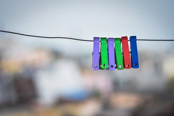 closeup of colorful clothes pegs on iron line